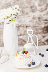 Tasty Pavlova Dessert with blueberry. Autumn tea time vibes background. Hygge aesthetics. Cozy home