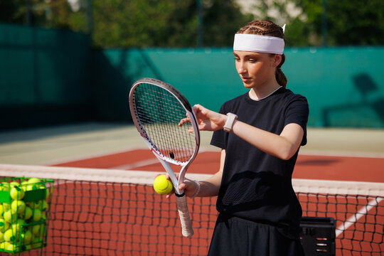 girl tennis player adjusts the strings of a tennis racket close-up during a match - Powered by Adobe