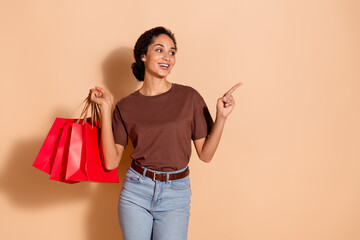 Photo of cheerful lovely adorable woman wear stylish clothes recommend offer empty space isolated on beige color background