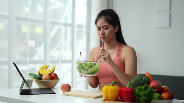 Young Asian woman in good health who is feeling anorexic. Doesn't want to eat. Woman is fasting in a salad bowl. Don't like or get bored with eating fresh, nutritious, tasty, healthy vegetables.