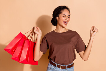 Photo of positive glad woman wear brown stylish clothes celebrate offer hold packages isolated on...