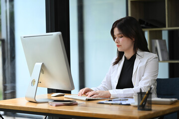 Focused female entrepreneur working with financial data at office desk