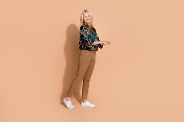 Photo portrait of blonde hair happy mature business lady in glamour shirt ride empty space transport isolated on beige color background