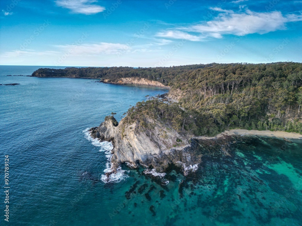 Wall mural aerial view of coastal cliffs and clear blue waters