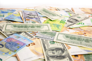 A close-up shot of a pile of various US dollar and euro banknotes
