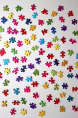 Colorful jigsaw puzzle pieces on white background. Flat lay.
