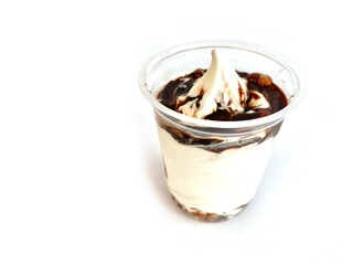 Delicious vanilla ice cream with chocolate syrup in a plastic cup isolated on white background