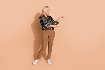Photo portrait of blonde hair happy pensioner business woman direct finger measure product delivery option isolated on beige color background
