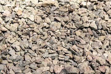 A close-up view of small, grey rocks on a sunny day