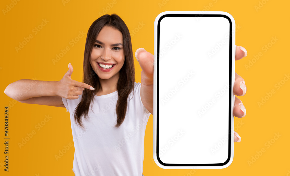 Aufkleber Check This Website. Portrait of smiling female holding smartphone with white blank screen in hand, showing device close up to camera and pointing finger at gadget with empty free space for mock up