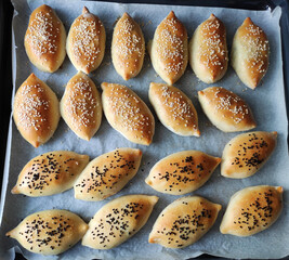 Delicious traditional oriental baked pies with filling, sprinkled with sesame seeds and black cumin