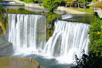Aerial view of the Pliva Waterfall and the nearby tourist observation deck. Landscape with the main attraction of Jajce (Bosnia and Herzegovina): a large, high waterfall in the center of the city