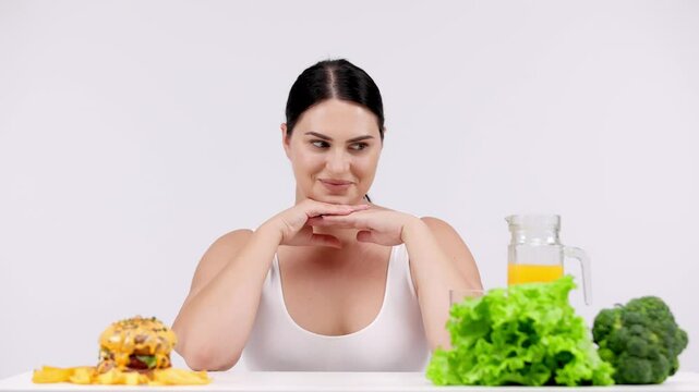 Full-figured woman on a light background choosing healthy food over less nutritious options. Perfect for promoting conscious decisions for a healthier and balanced diet