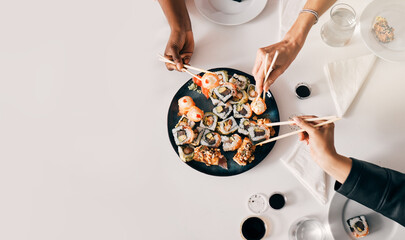 Above, sushi or hands of people with chopsticks for lunch, luxury meal or takeaway food in office. Japanese cuisine, utensils or women at table for sharing, high quality catering or business expense