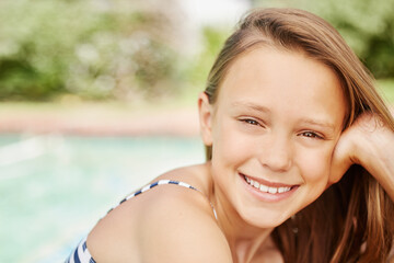 Fototapeta premium Child, portrait and girl with smile in swimming pool to chill or relax for wellness in water on vacation. Holiday, activity or face of kid at hotel resort in summer for weekend break in Australia