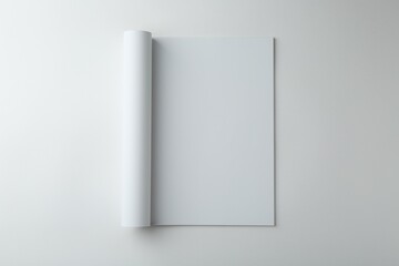 Naklejka premium Open magazine with blank page on white background, top view. Mockup for design