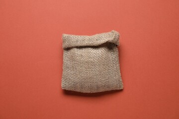 One burlap sack on color background, top view