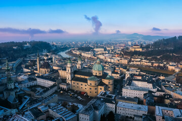Aerial view of winter Salzburg showcasing historic architecture and serene river landscapes at dawn