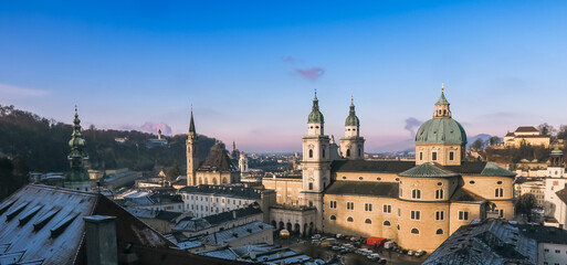 Naklejka premium Winter morning in Salzburg showcasing historic architecture and scenic winter landscape under clear skies