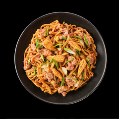 Delicious stir-fried noodles with vegetables and meat served in a black bowl, garnished and ready to eat