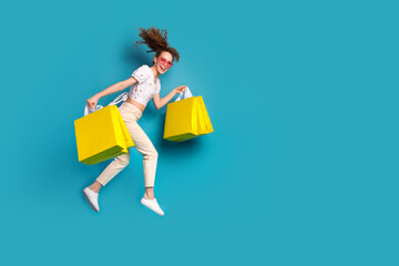 Full body photo of young woman heart sunglass shopping bags jump runner dressed stylish white clothes isolated on blue color background