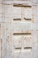 Casetones en relieve en muro de piedra blanca