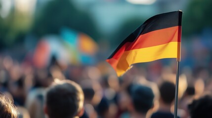 German flag waving in vibrant crowd - national pride and unity concept for holiday celebrations
