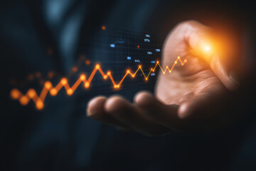 Fototapeta premium A hand holding digital representation of declining interest rate chart, showcasing financial trends and data analysis. glowing elements emphasize importance of understanding market fluctuations