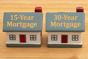 Terms of mortgage with two houses on wood desk