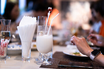 Chilled yogurt drink in a cocktail glass with a straw on the table during dinner time