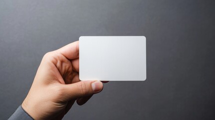 Hand holding Identification white blank id card on gray background