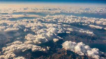 Fototapeta premium Aerial view from airplane window at high altitude of dense puffy cumulus clouds flying in evening