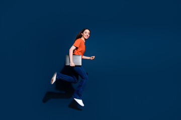 Photo of lovely adorable cheerful woman wear orange stylish clothes hold netbook isolated on dark blue color background