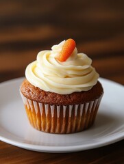 A delicious cupcake topped with creamy frosting and a small decorative carrot.