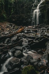 Serene waterfall cascading over rocks in a lush forest setting, captured with a long exposure effect