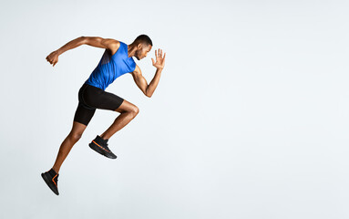 Doing Exercise. Full length portrait of muscular afro man with high knee, lifting leg and waving arm, copyspace