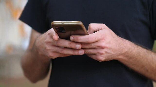 Close-up view of hands typing a message on a smartphone, highlighting the text input process. The focus is on the fingers and screen interaction.