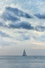 Beautiful sunset over the ocean and a small yacht 