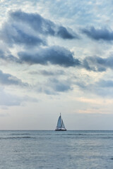 Obraz premium Beautiful sunset over the ocean and a small yacht 