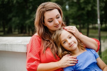 Obraz premium a woman and a little girl are sitting on a bench in a park