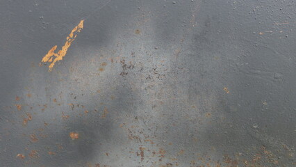  a close-up of a surface that appears to be metal. The surface has a grayish color with some areas of rust, particularly a noticeable rust spot towards the top left