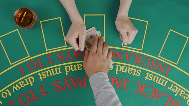 Gaming and casino payment concept. Top view of blackjack casino table, woman player counting dollar banknotes and giving money to the croupier.