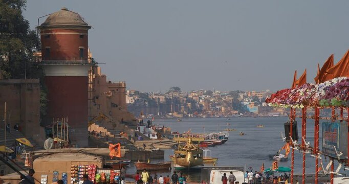 Varanasi, India. View On Ganga Mahal Ghat. Boats Moored On Ganga River Near Lassi Ghat And Tulsi Ghat. Family Holiday Vacation In India Slow-Mo. Gold Richly Decorated Pleasure Boat With Statue Of