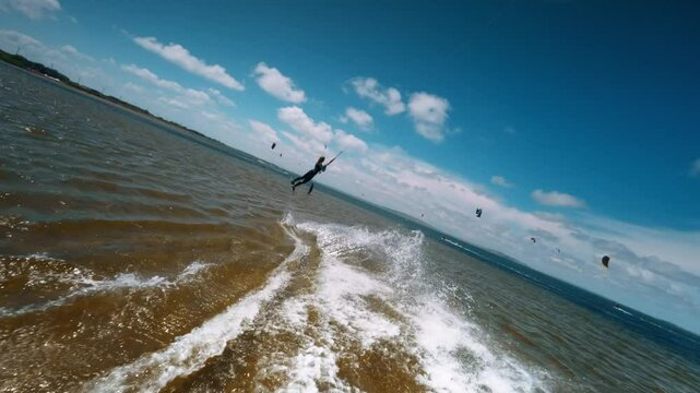professional kiter performs a difficult trick against the backdrop of beautiful splashes and wonderful views. female kiteboarder performs a trick, slow motion