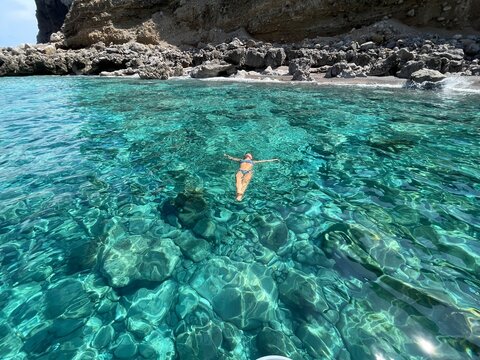 ragazza nuota nel mare trasparente in sicilia 