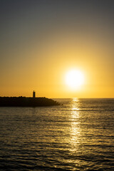 A breathtaking sunset at Nazaré, Portugal, with the sun dipping below the horizon, framed...