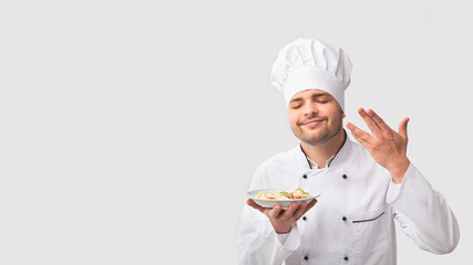 Cooking Food. Chef Man Holding Plate Smelling The Aroma Of Dish Standing Over White Studio Background. Panorama