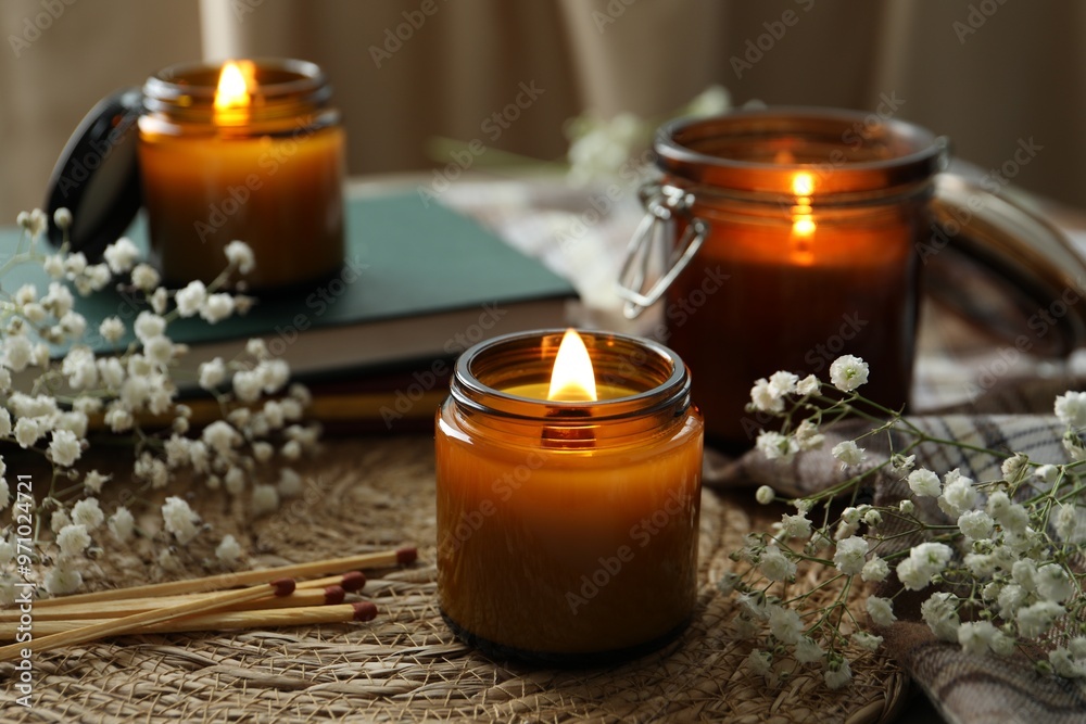 Sticker Burning candles and beautiful flowers on table