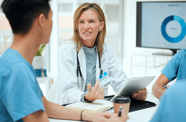 Doctor, meeting and medical students on tablet with group for healthcare, review or feedback. People, talking and technology in discussion for teamwork, staff and internship in clinic or hospital