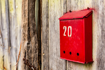 Red letterbox, mailbox number 20, twenty. Autumn perspective, details from the streets of Debnevo, village in Northern Bulgaria